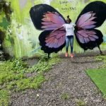 une élève devant un oeuvre de street art "papillon"