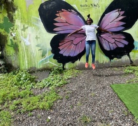 une élève devant un oeuvre de street art "papillon"